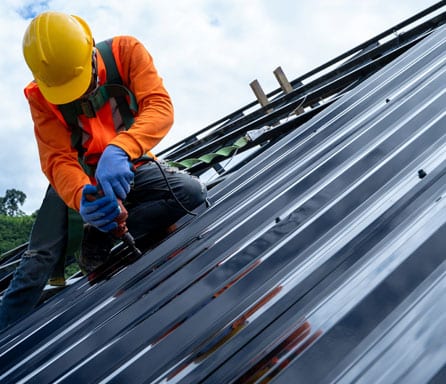 Ben Ross Roofing | Rock Hill, South Carolina | man in bright orange shirt installing a metal roof